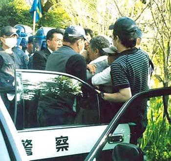 白いシャツに帽子をかぶっているのが市東孝雄さん（手前右から二人目）。千葉県警がパトカーに連れ込もうとするところを、体を張って阻止する反対同盟・萩原さん